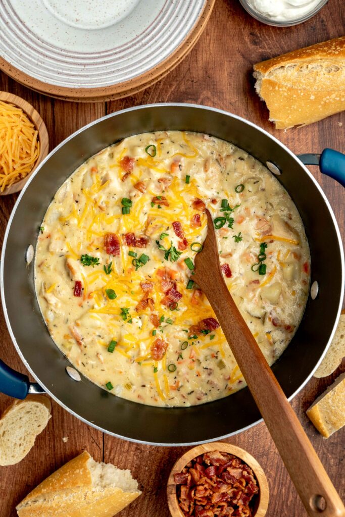 creamy potatoes, chicken, bacon, and vegetables combined in a pot.