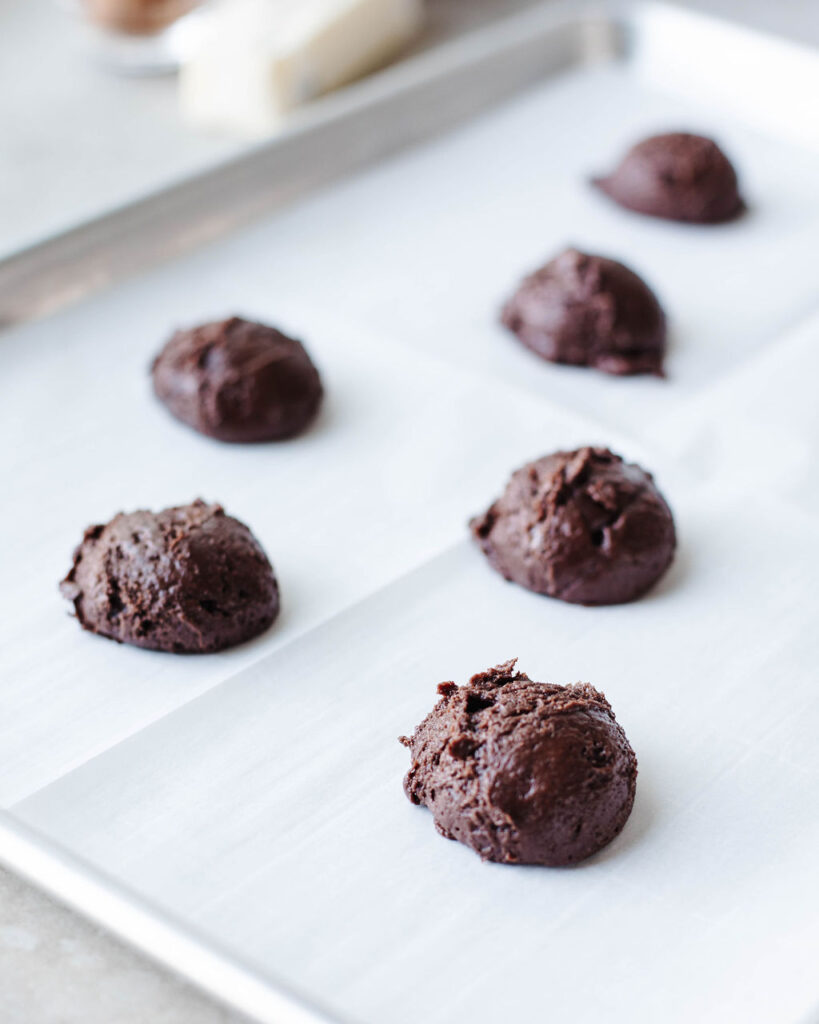 cookie dough scoops on a piece of parchment paper.