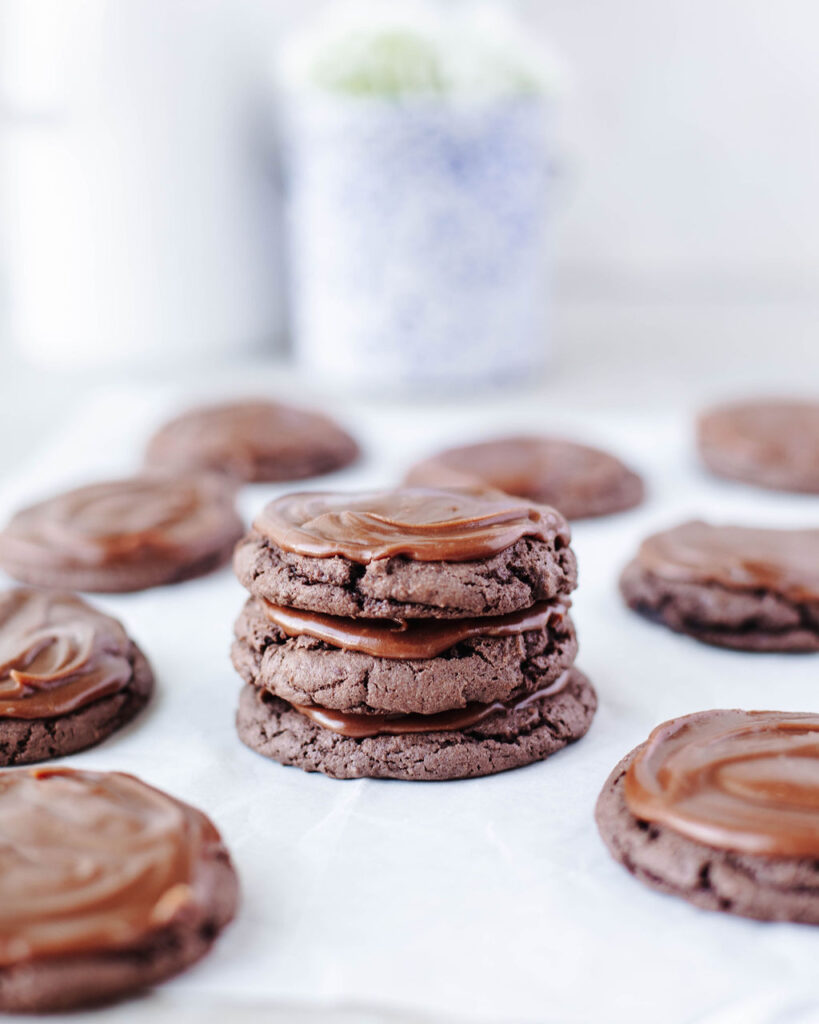 a stack of chocolate cake mix cookies with frosting.