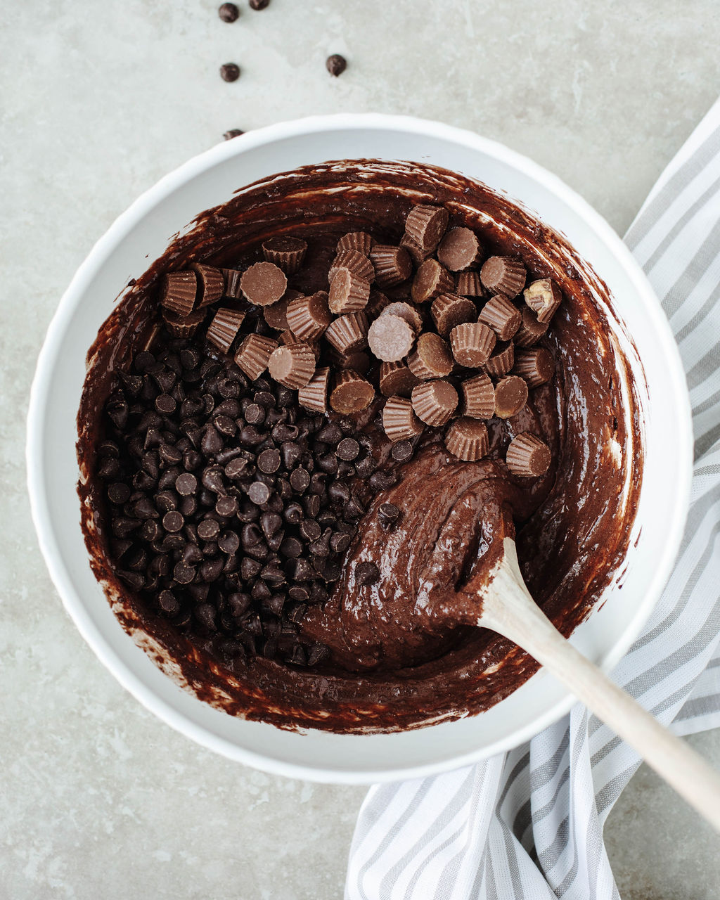 add in's folded into chocolate cake batter in a white mixing bowl.