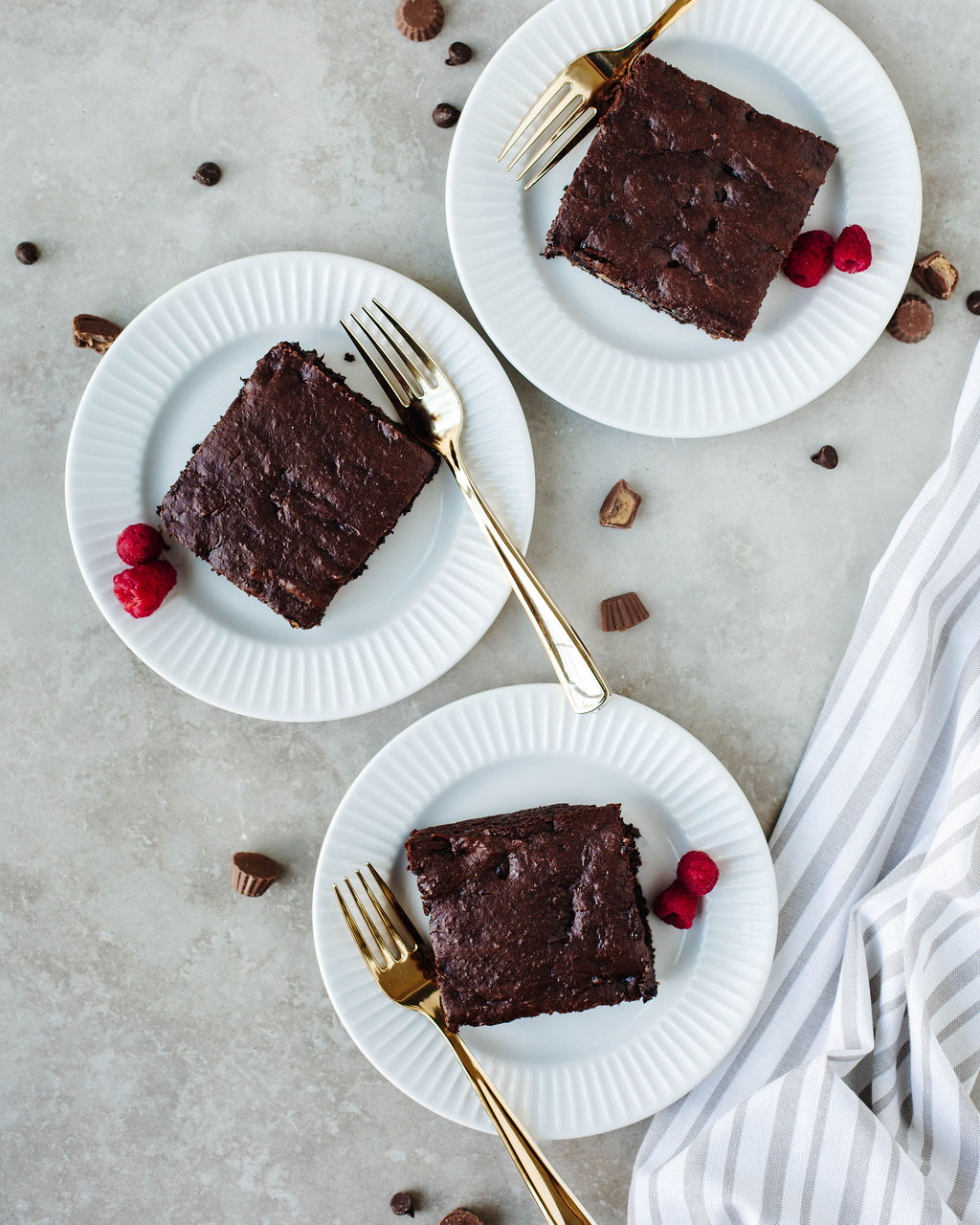 slices of chocolate peanut butter cake on white plates.