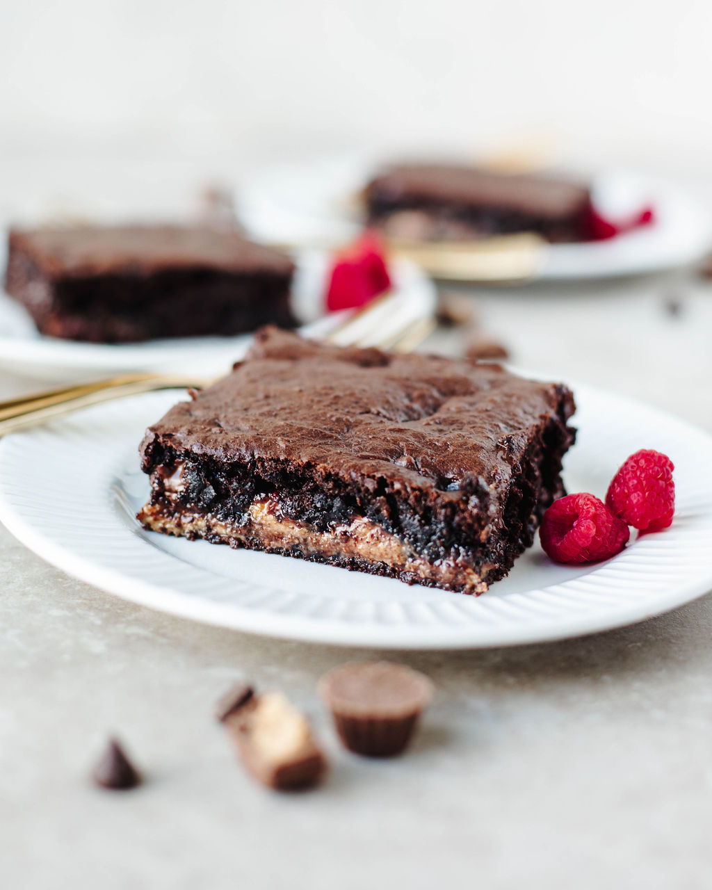Close-up of a moist chocolate peanut butter dump cake slice on a plate with raspberries.