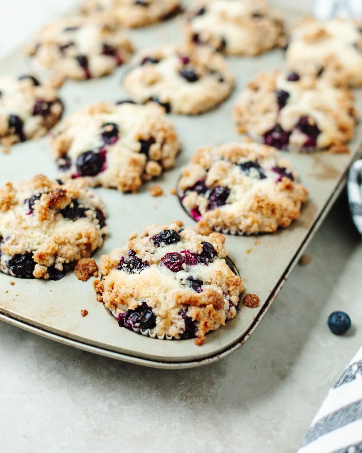 blueberry streusel muffins baked in a muffin pan.