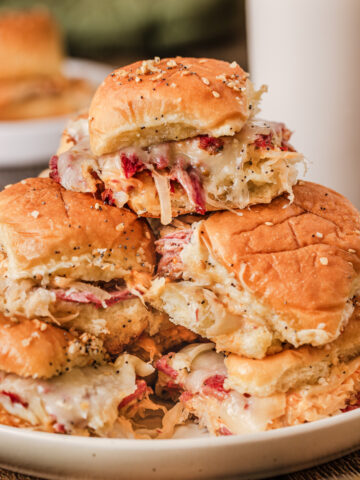 a stack of corned beef sliders on a serving plate.