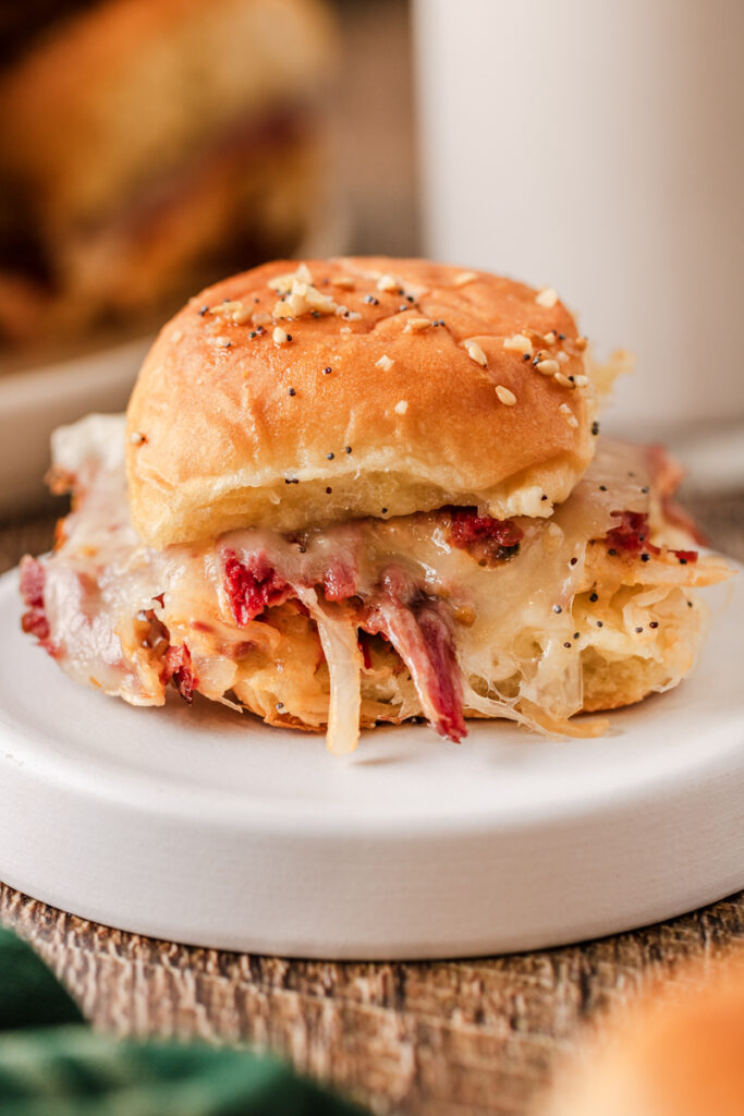 an up close look of a slider with corned beef, Sauerkraut, and cheese.