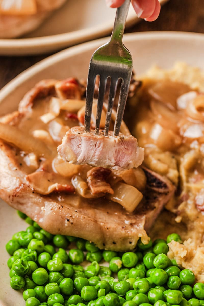 tender pork chops cooked and served on a plate.