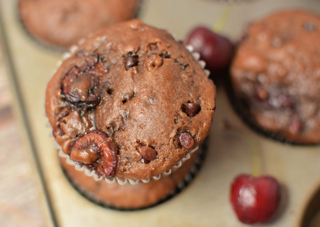 a stack of tender muffins with chocolate chips and cherry pieces throughout.