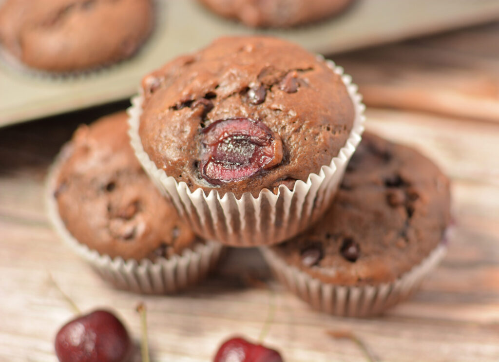 baked chocolate cherry muffins with paper liners.