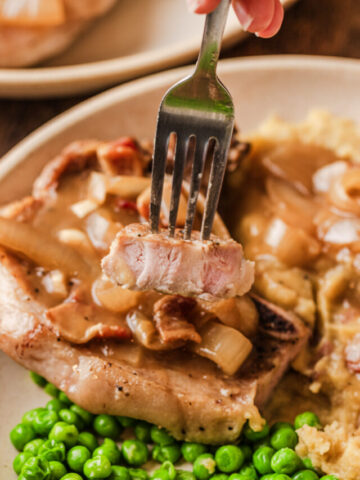 tender pork chops cooked and served on a plate.