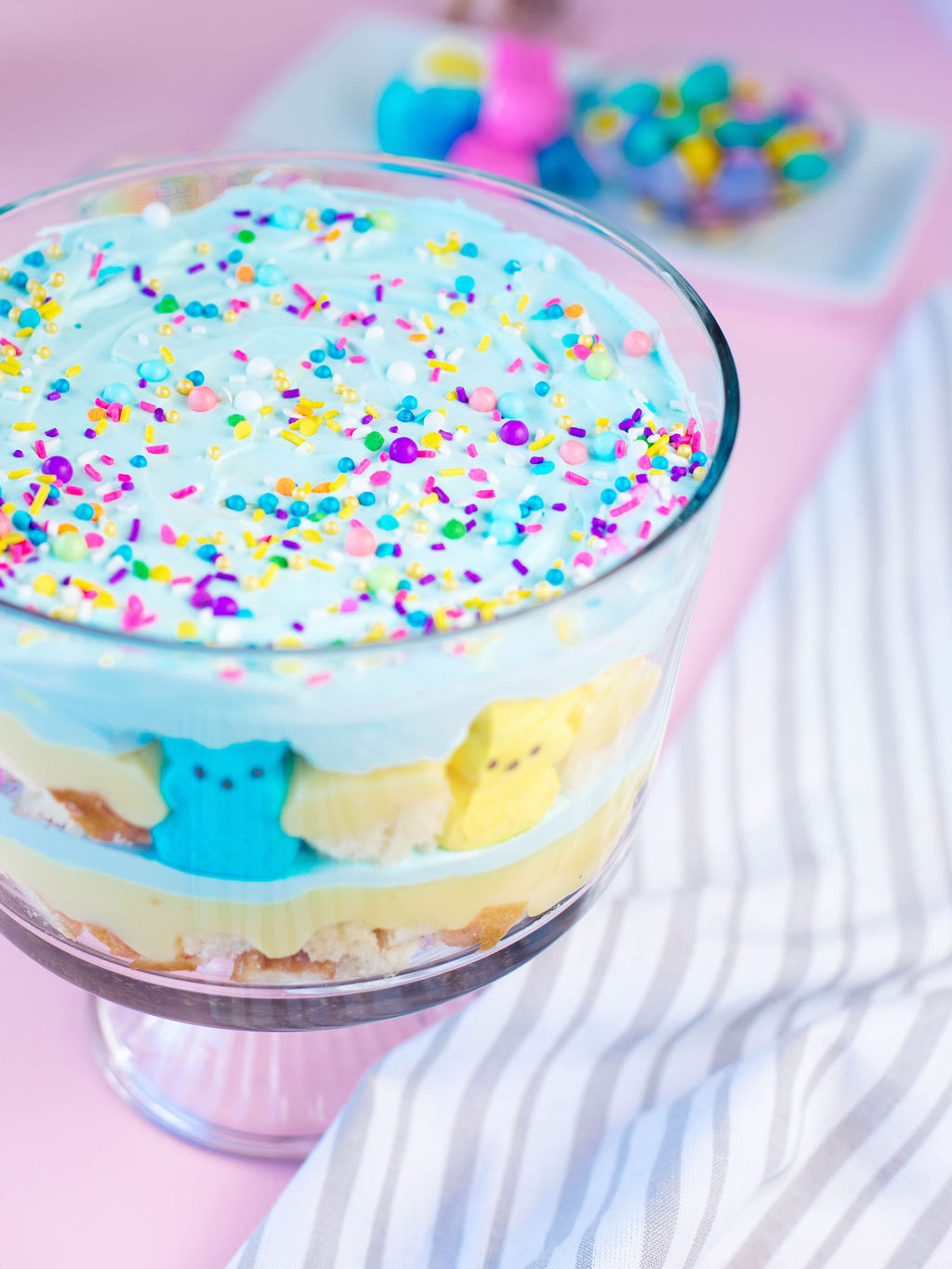 an Easter trifle made of layered cake, cool whip, pudding, and candies.