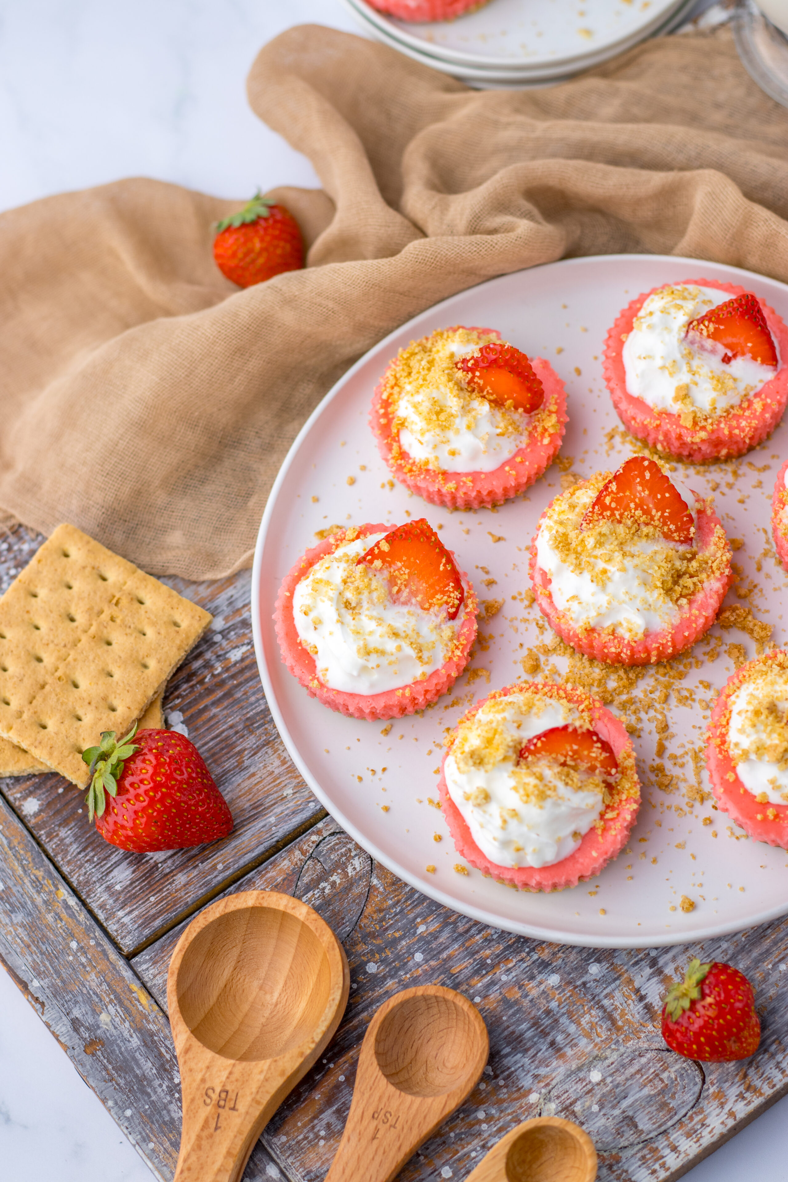 a plate of mini strawberry cheesecakes ready to serve and enjoy.
