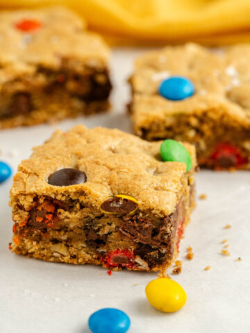 thick, chewy, and loaded with chocolate monster cookie bars ready to serve.