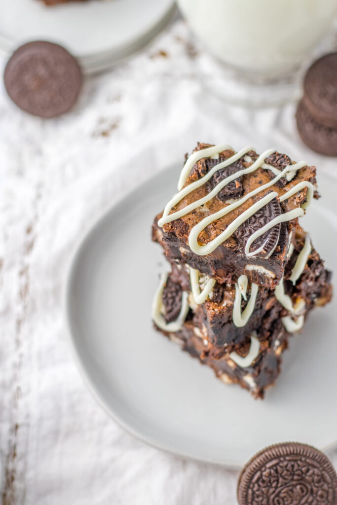 white chocolate drizzled over homemade brownies with Oreo cookie pieces throughout.
