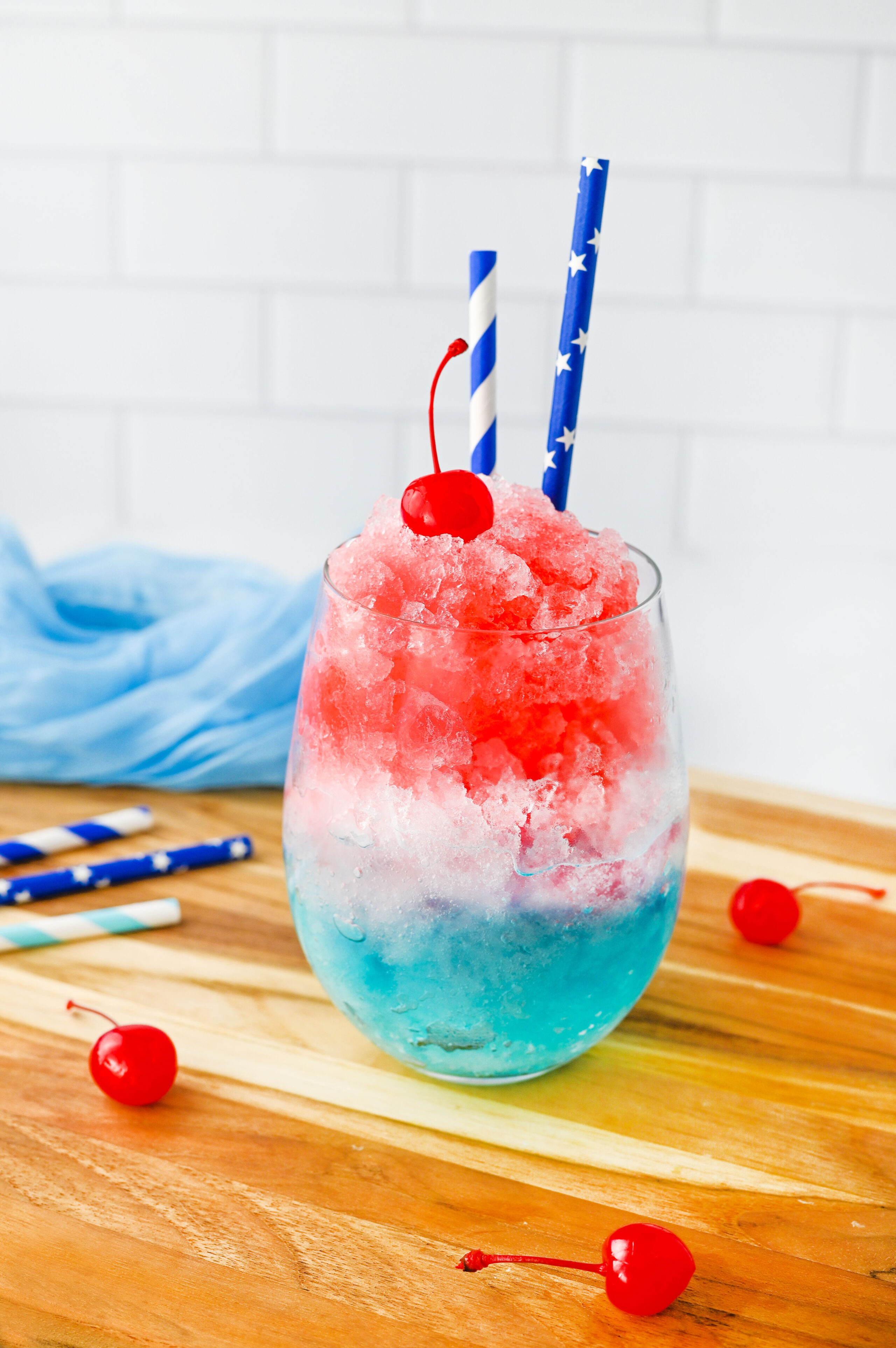 a red, white and blue layered slushie in a glass.