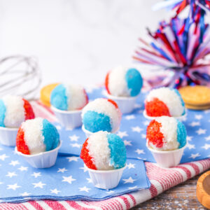 red, white, and blue sand sugar cookie balls in a paper cup.