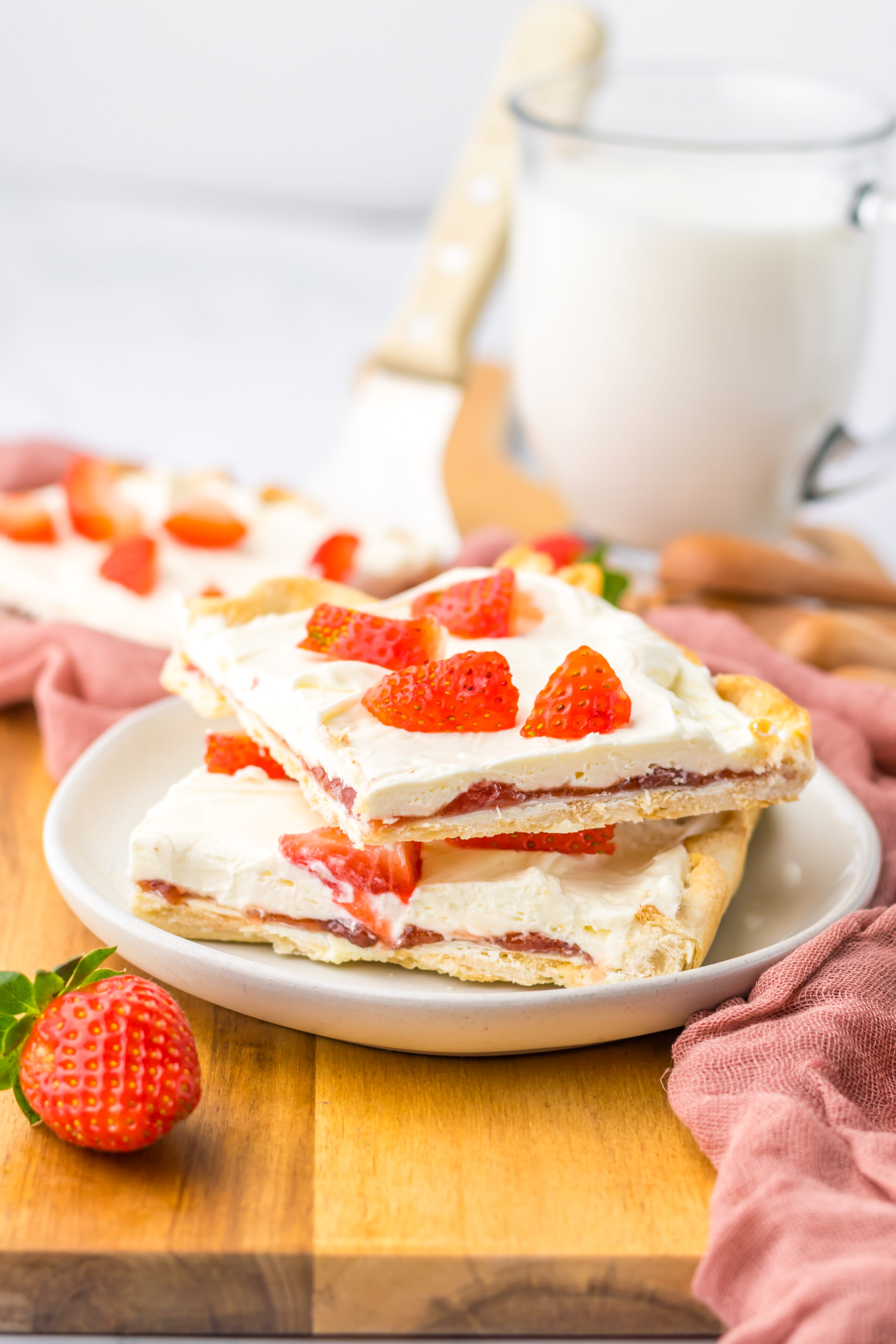 pieces of strawberry cream cheese slab pie served on white dessert plates.