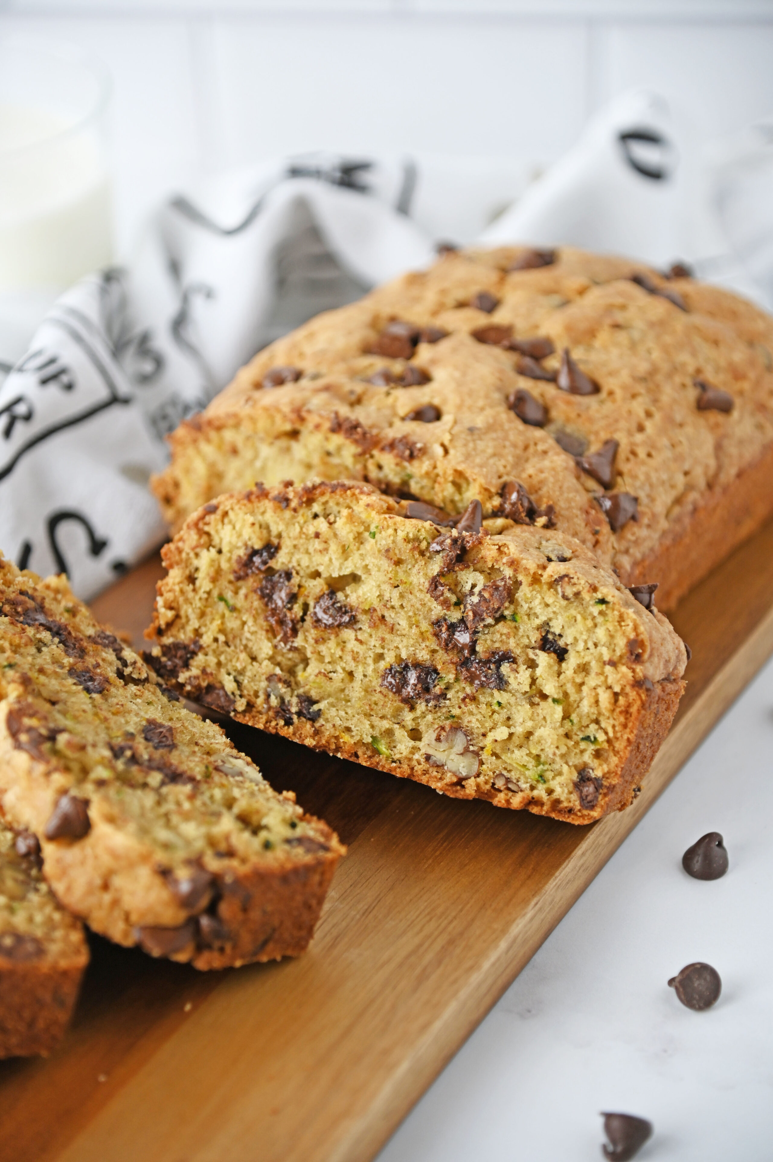 a zucchini bread loaf on a cutting board with chocolate chips throughout.
