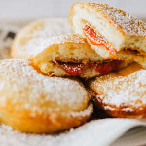 peanut butter and jelly sandwiches fried and sliced in half on a plate.