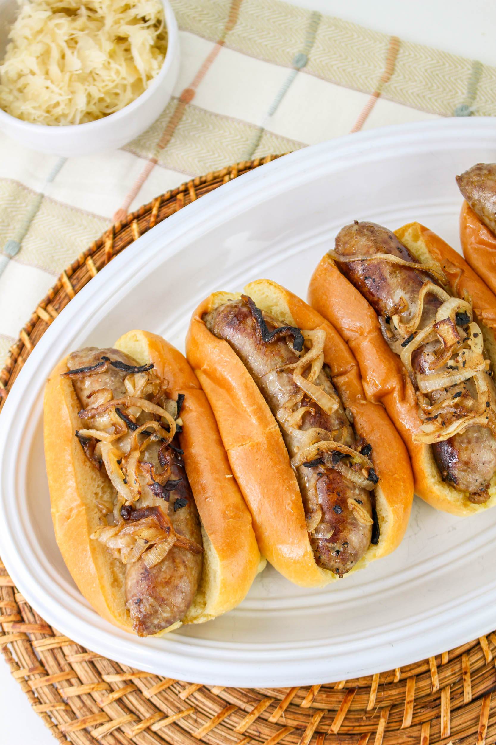 oven roasted beer brats on a white plate.