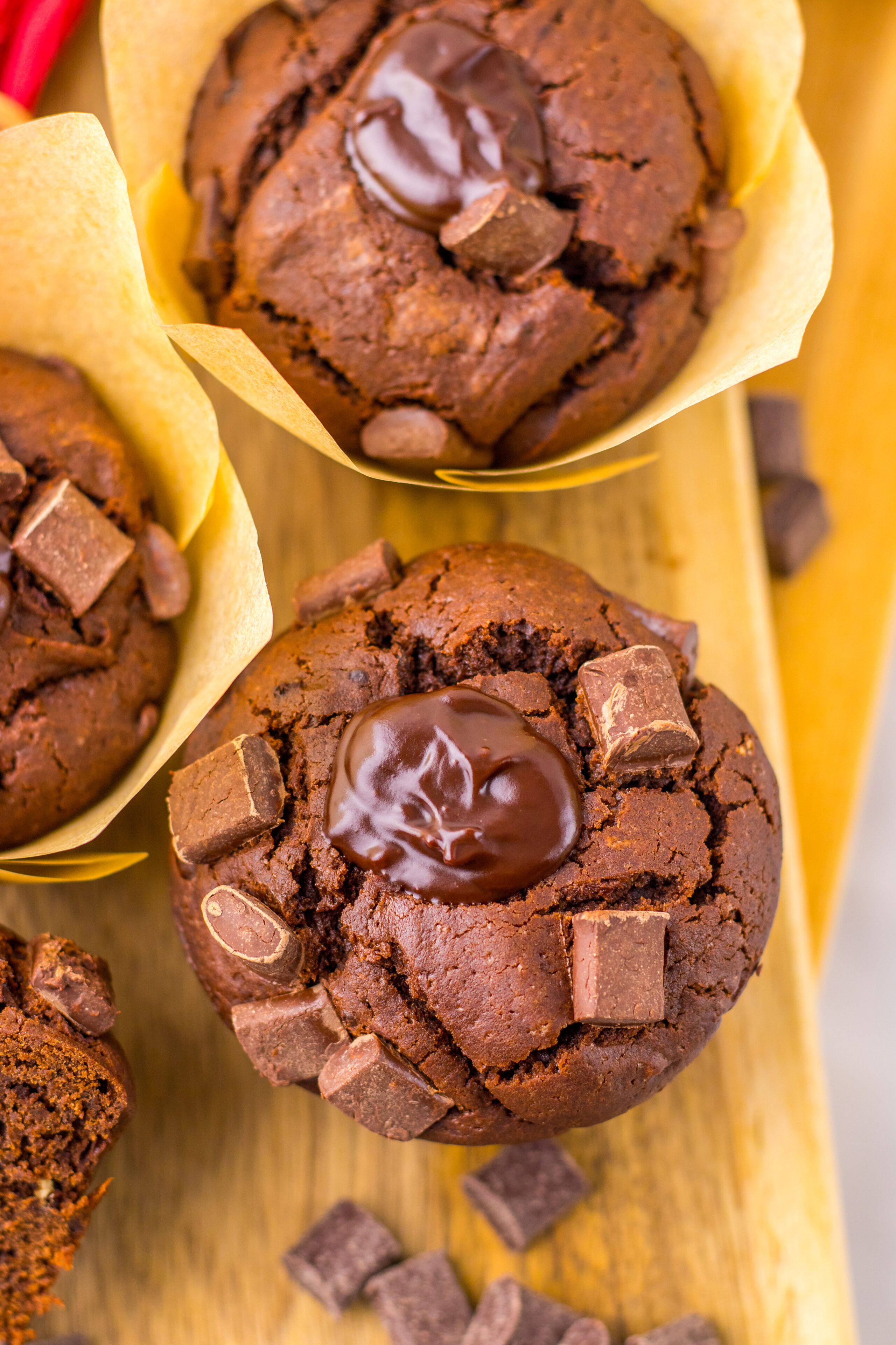 chocolate muffins with a ganache center on a cutting board.