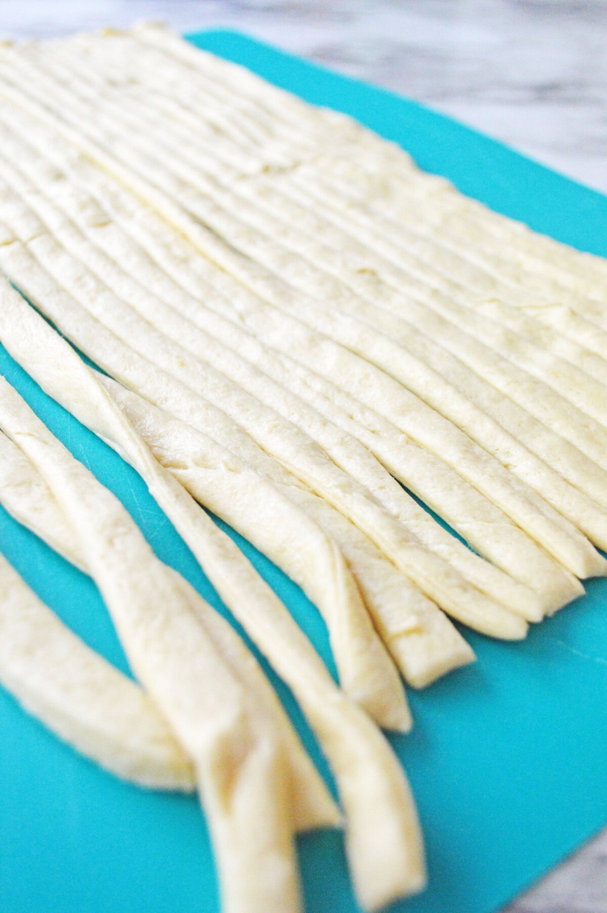 strips of crescent roll dough sliced using a pizza cutter.
