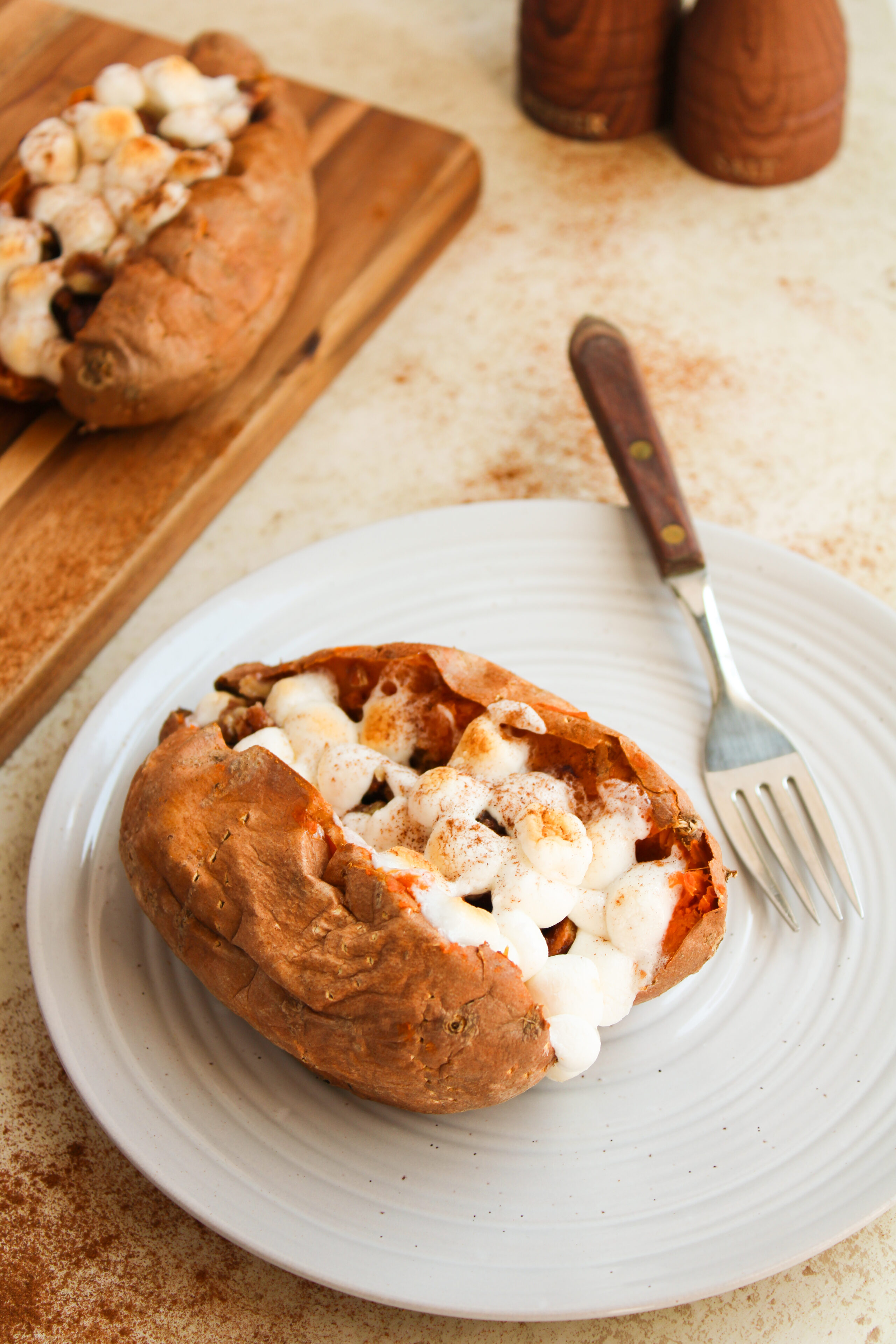 a loaded sweet potato on a white plate.