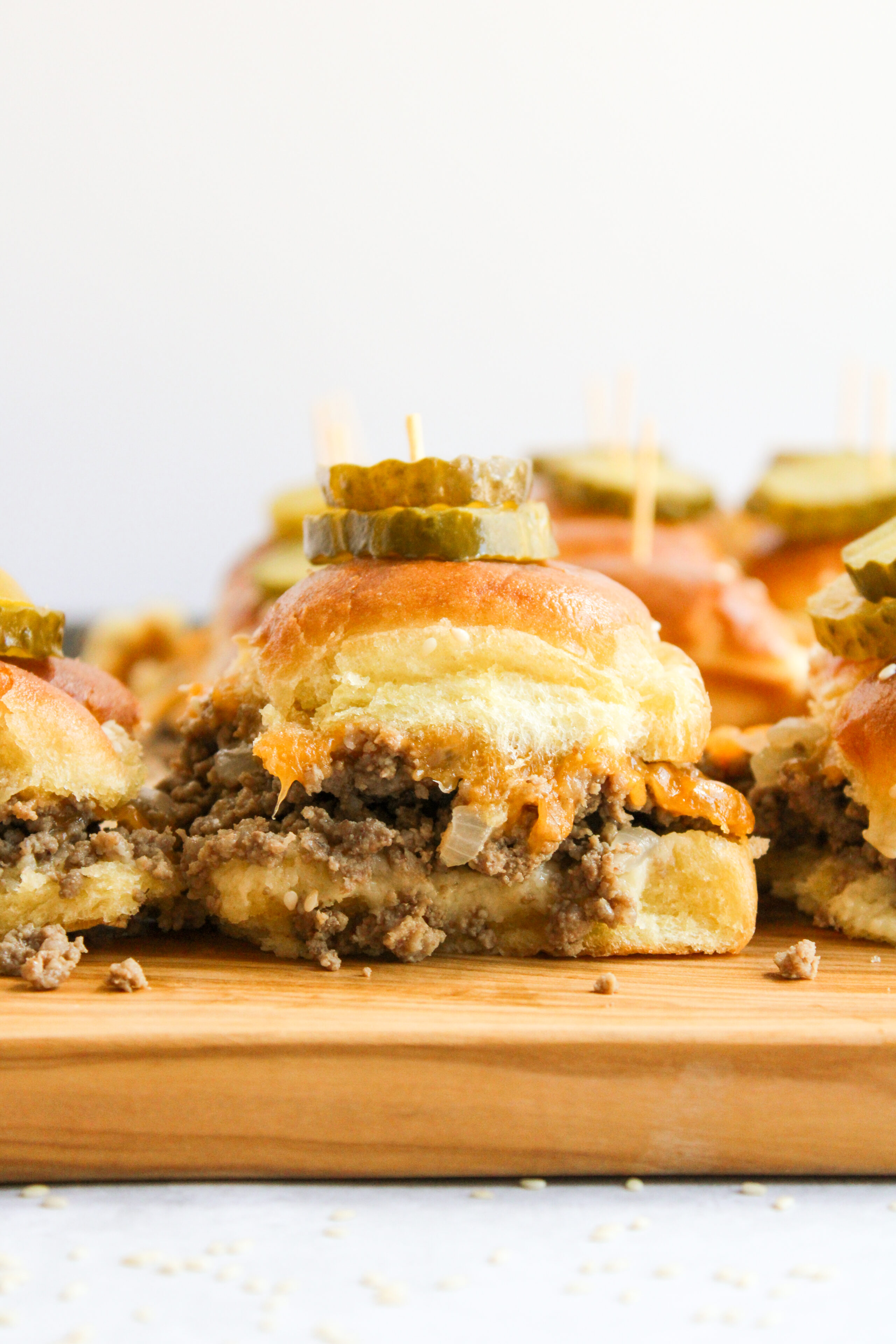 cheeseburger sliders on a wood cutting board.