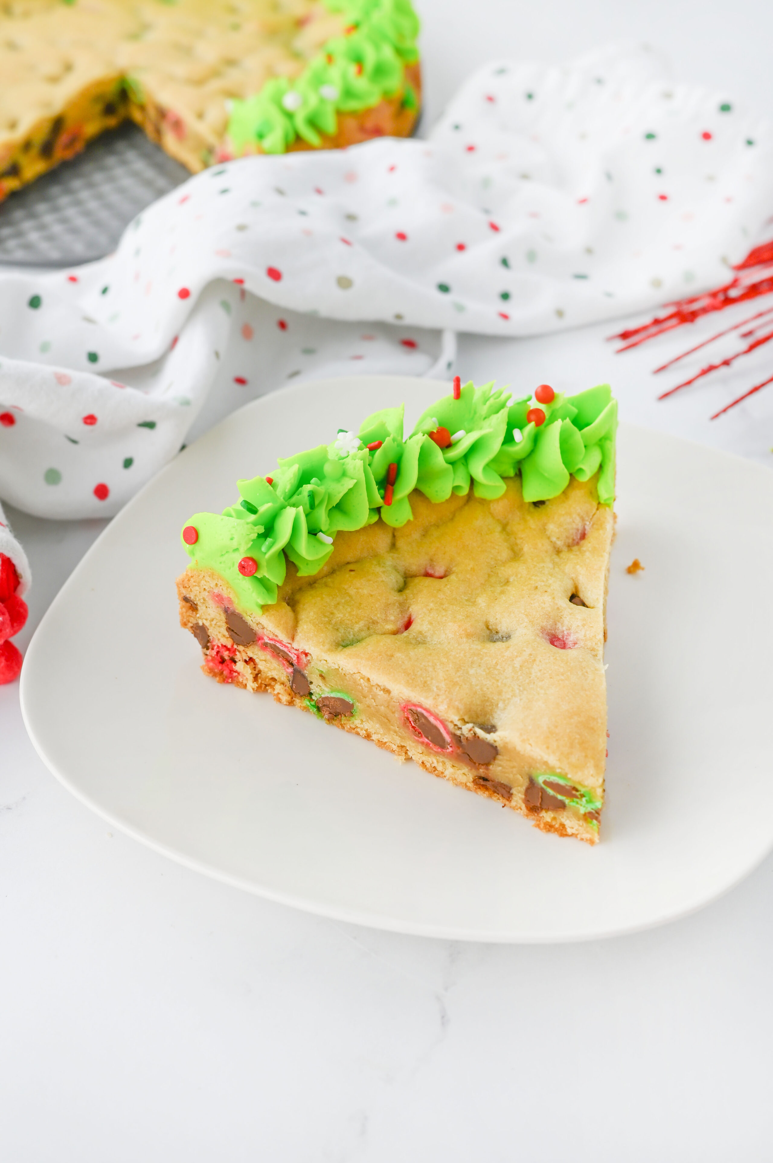 a slice of christmas cookie cake on a white plate.