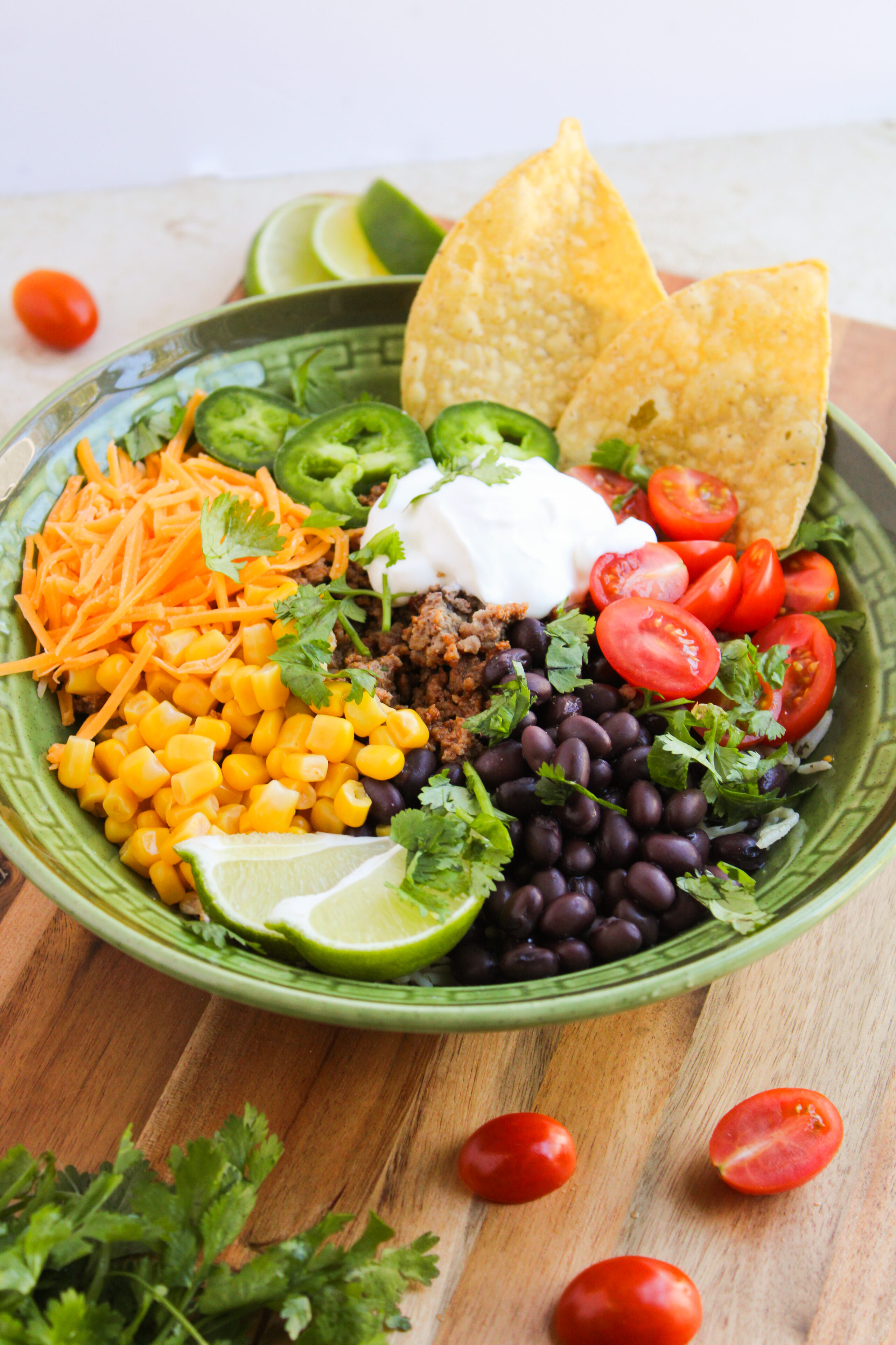 a taco bowl made in a green bowl ready to serve.