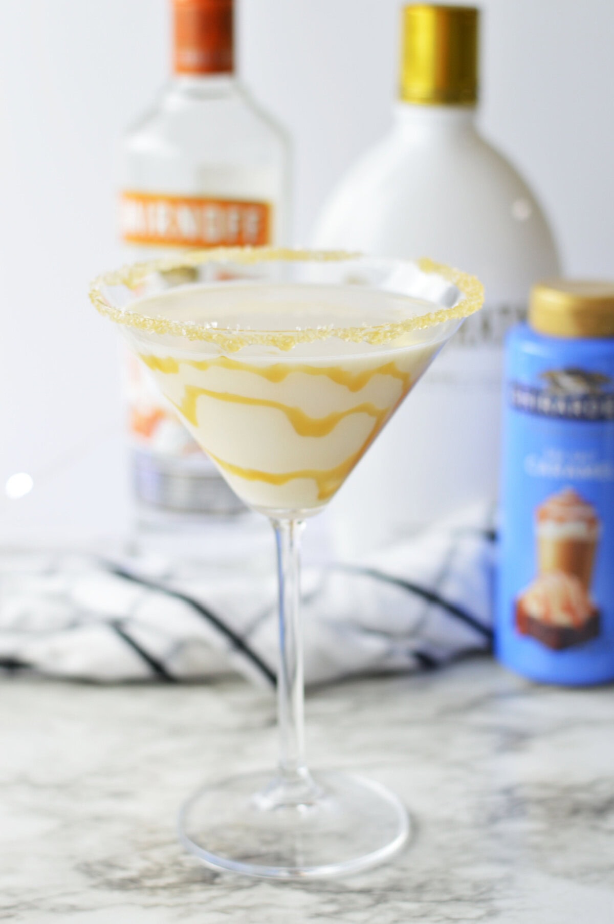 a two ingredients creamy martini with drizzled caramel sauce inside the glass.