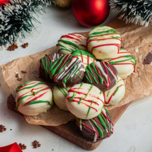 Christmas covered Oreos on a wood board.
