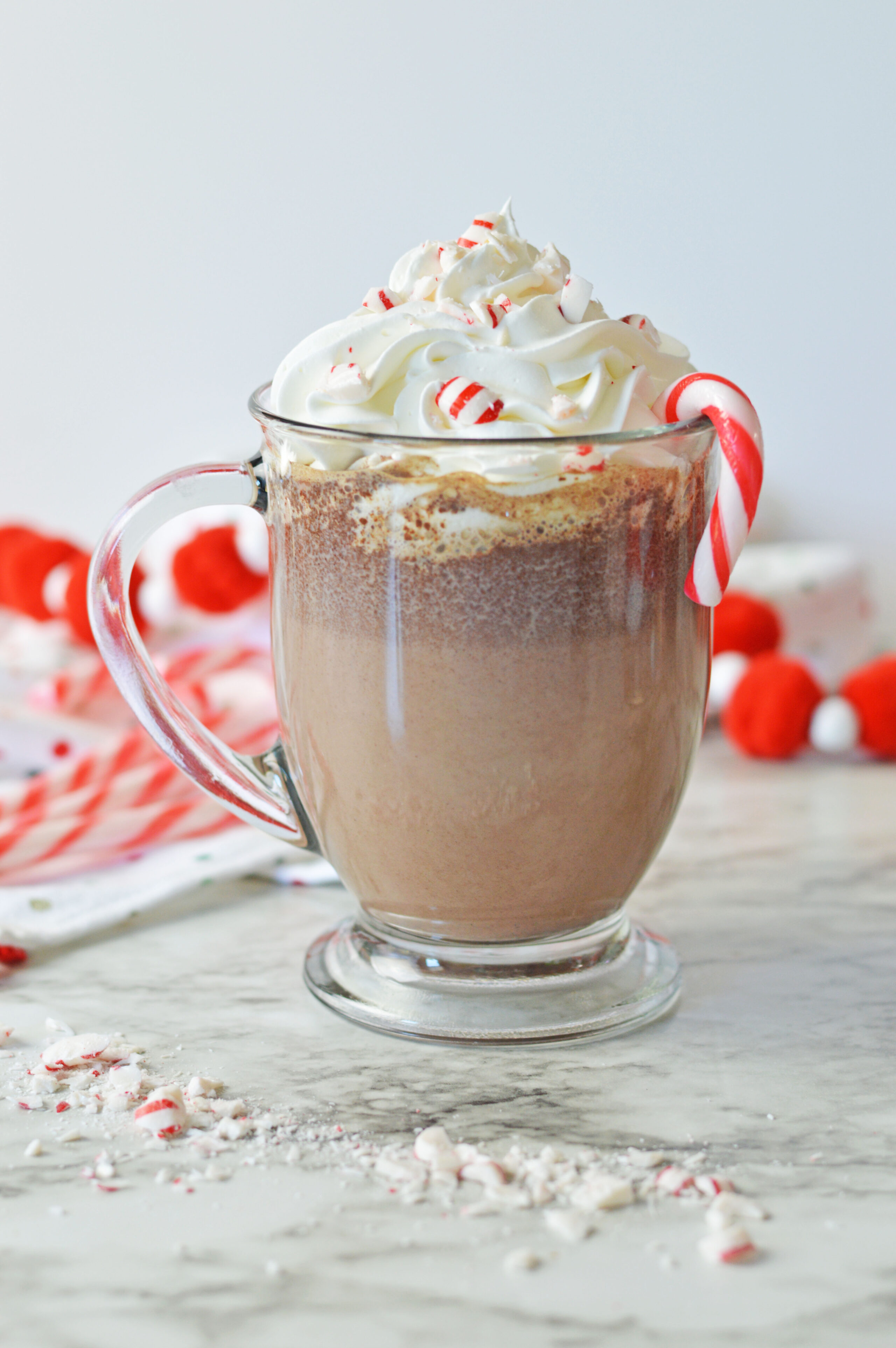 peppermint hot chocolate in a glass mug with whipped cream.