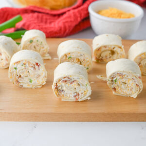 crack chicken pinwheels on a wood cutting board.