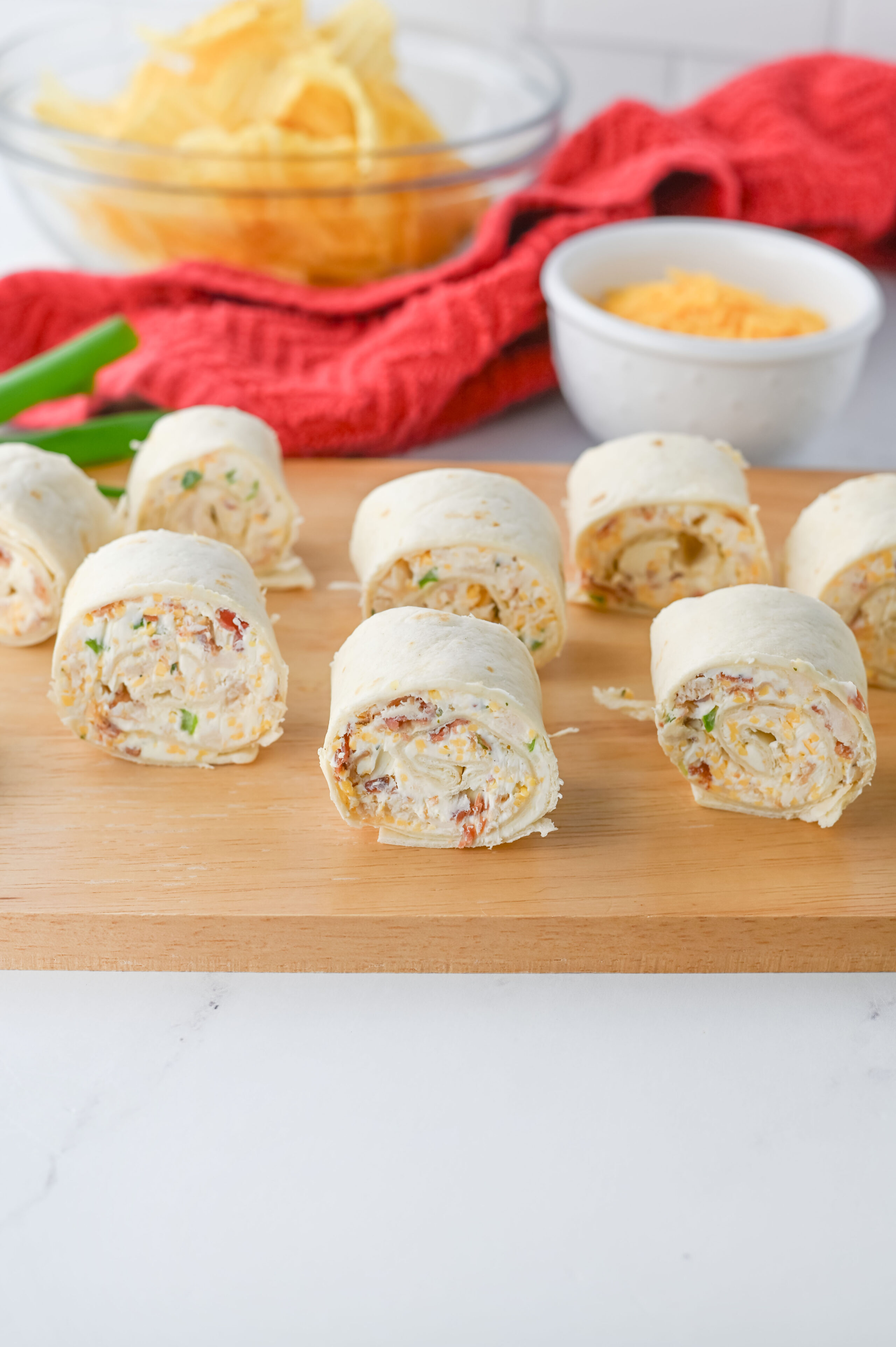 crack chicken pinwheels on a wood cutting board.