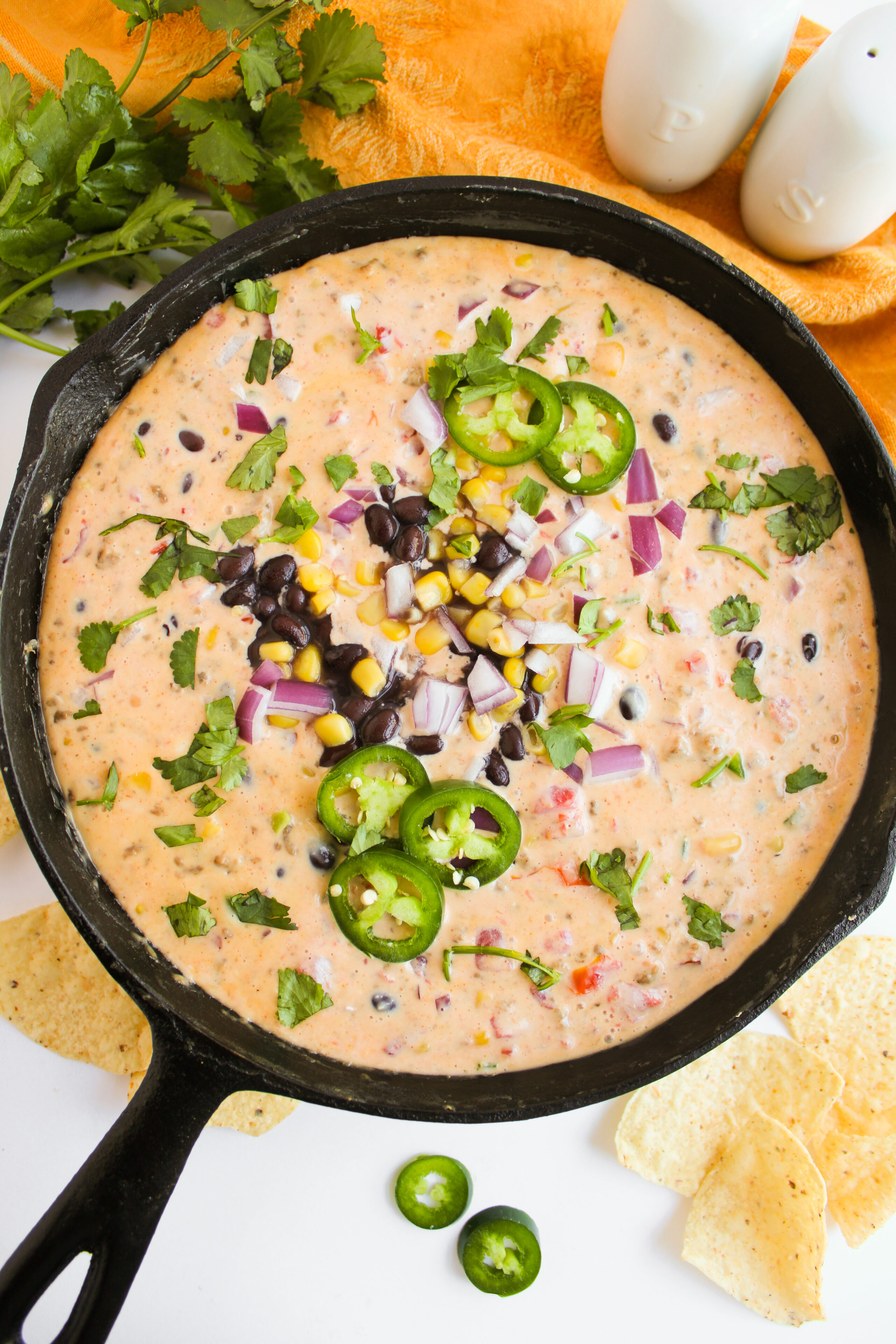 cheesy queso in a black cast iron skillet.