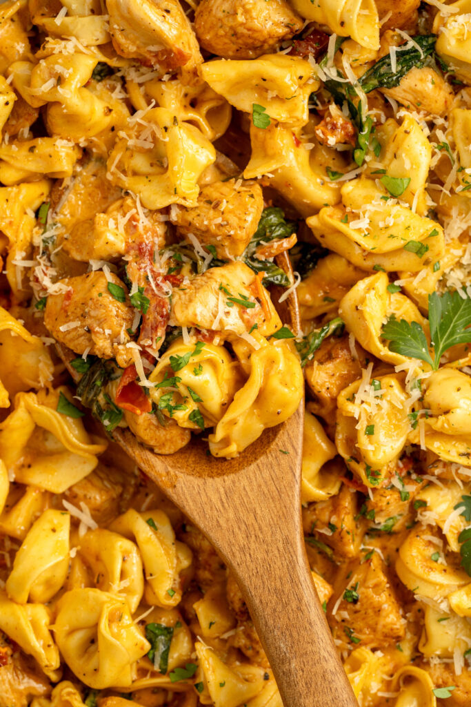 cheesy tortellini combined with chicken and a marry me cream sauce in a skillet.