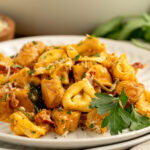 a tomato based pasta with chicken and seasonings.