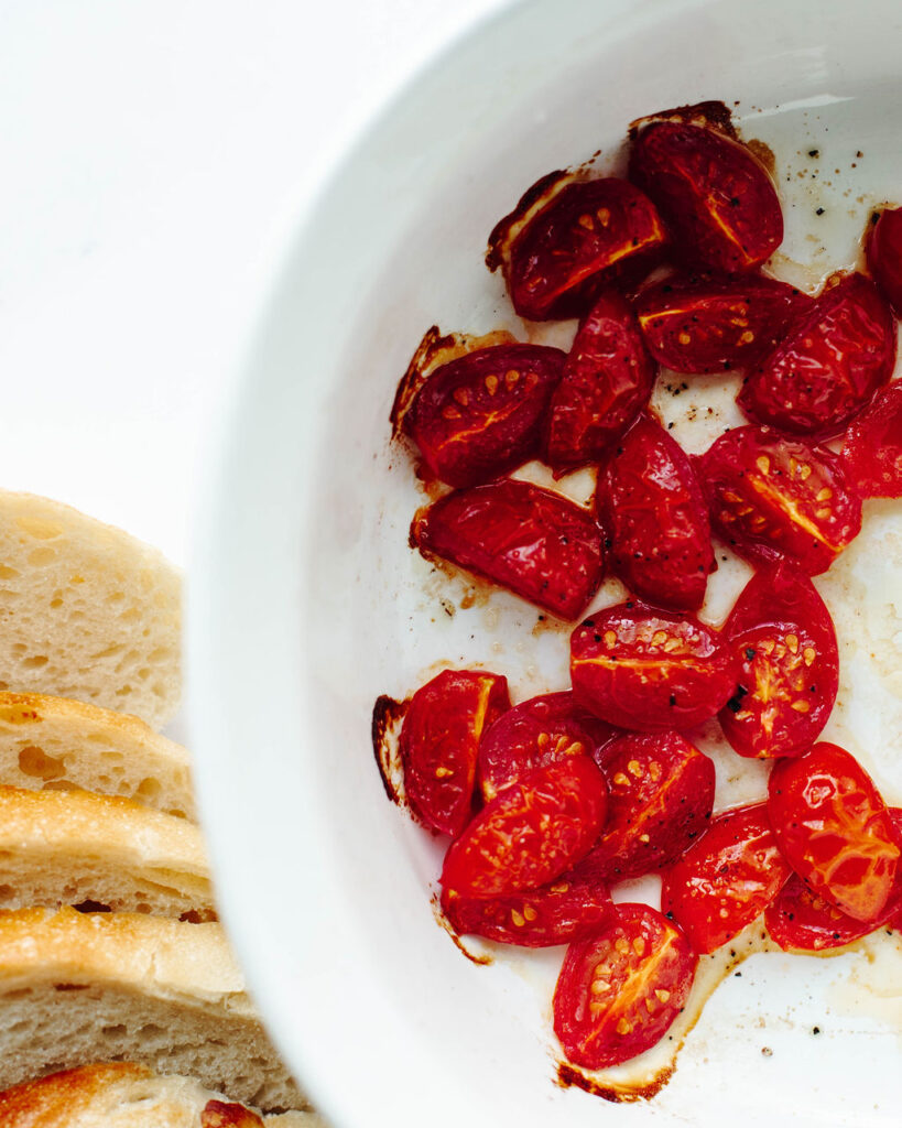 roasted tomatoes in a white baking dish.