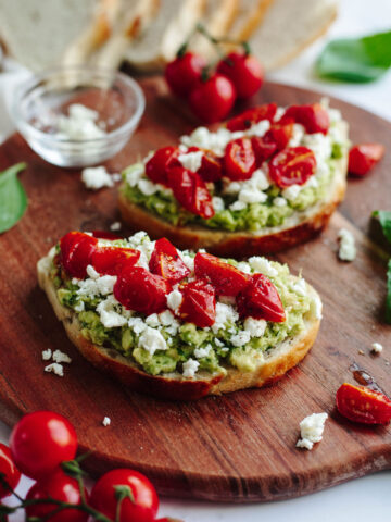 sourdough bread with mashed avocado and toppings.