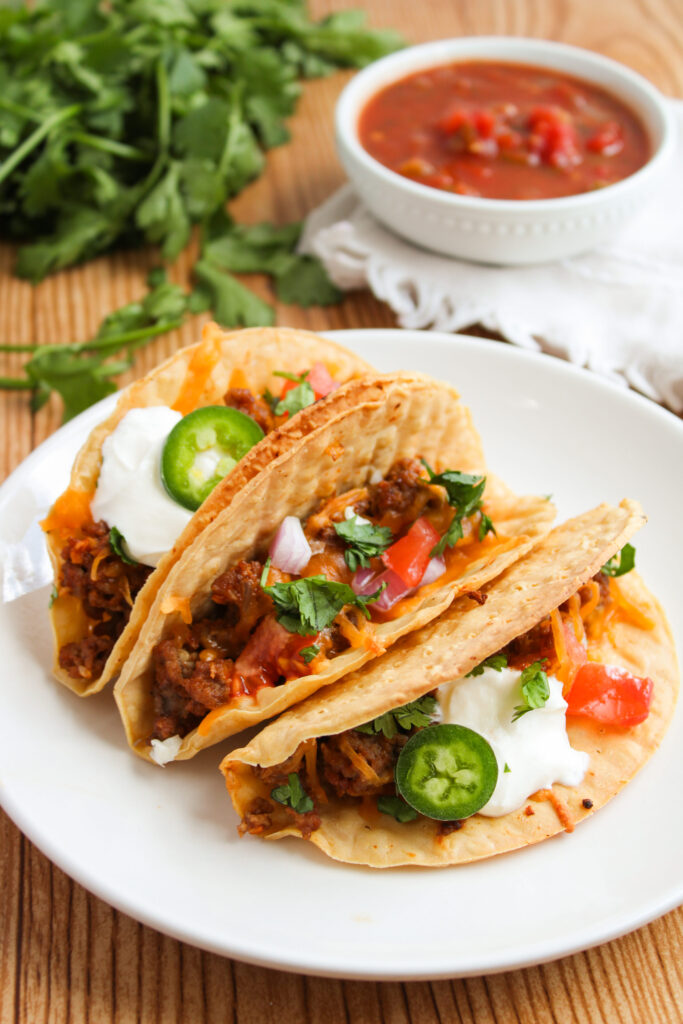 a serving of Mexican tortilla shells filled on a white plate.