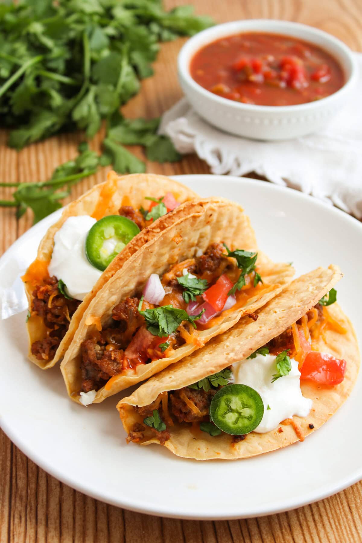 a serving of Mexican tortilla shells filled on a white plate.