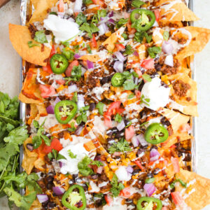 loaded chips with seasoned beef, beans, corn, and toppings.