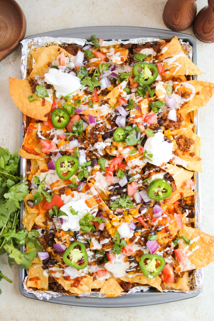 loaded chips with seasoned beef, beans, corn, and toppings.