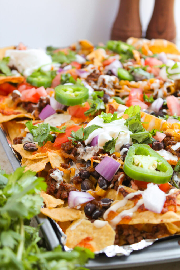 Loaded Ground Beef Nachos on a sheet pan.