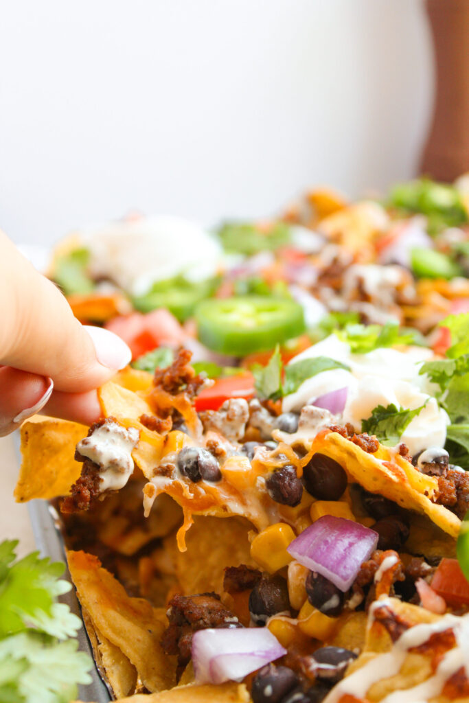 a serving of Ground Beef Nachos being scooped up.