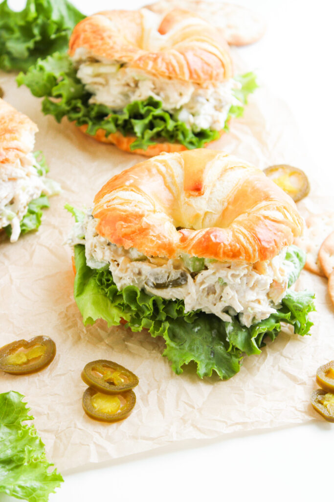 Uma salada simples servida em um croissant com alface e jalapenos.