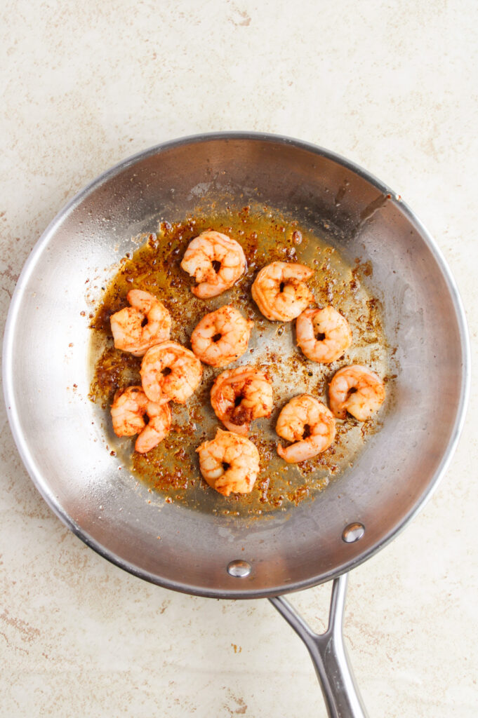 shrimp being cooked in a skillet with oil.