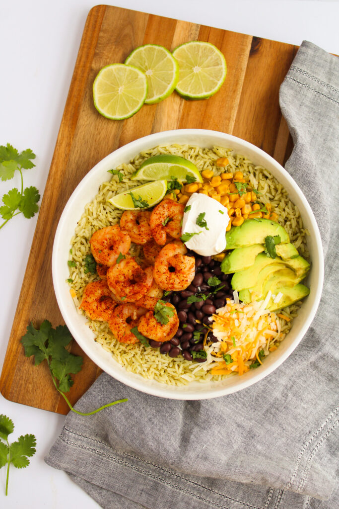 Shrimp Burrito Bowls with fresh avocado, sour cream, lime, and beans.