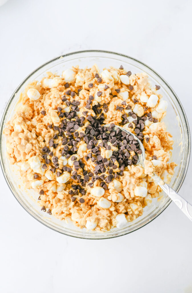 Mini pedaços de chocolate jogados em uma mistura de cereais Krispies de arroz.