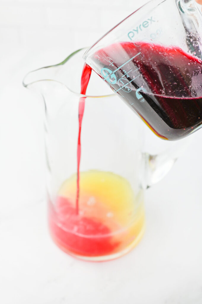 berry syrup combined in a pitcher with lemon juice.